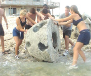 Rolling a reefball into the water.